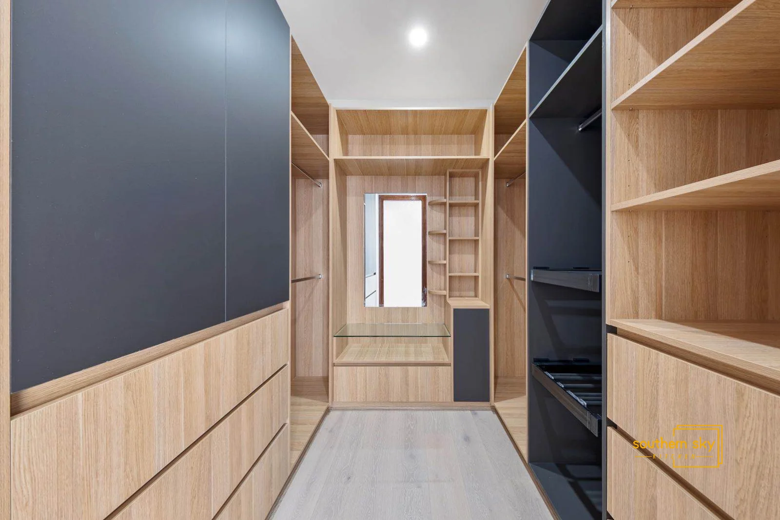 Luxurious walk-in closet with sleek lines, expert craftsmanship, and elegant wood finishes for ultimate sophistication.