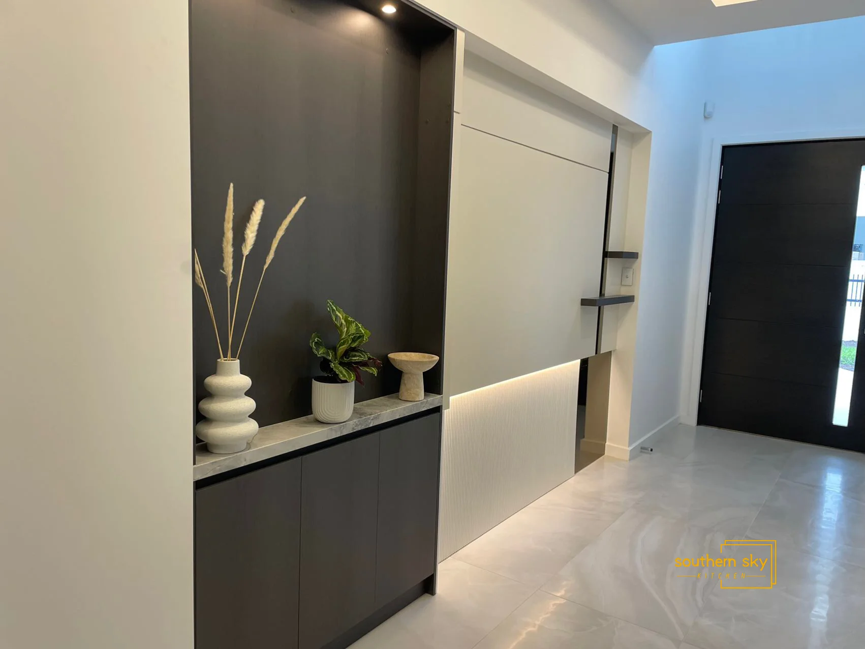 Elegant modern entryway with sleek cabinetry and chic decor, showcasing exquisite craftsmanship and sophisticated design.