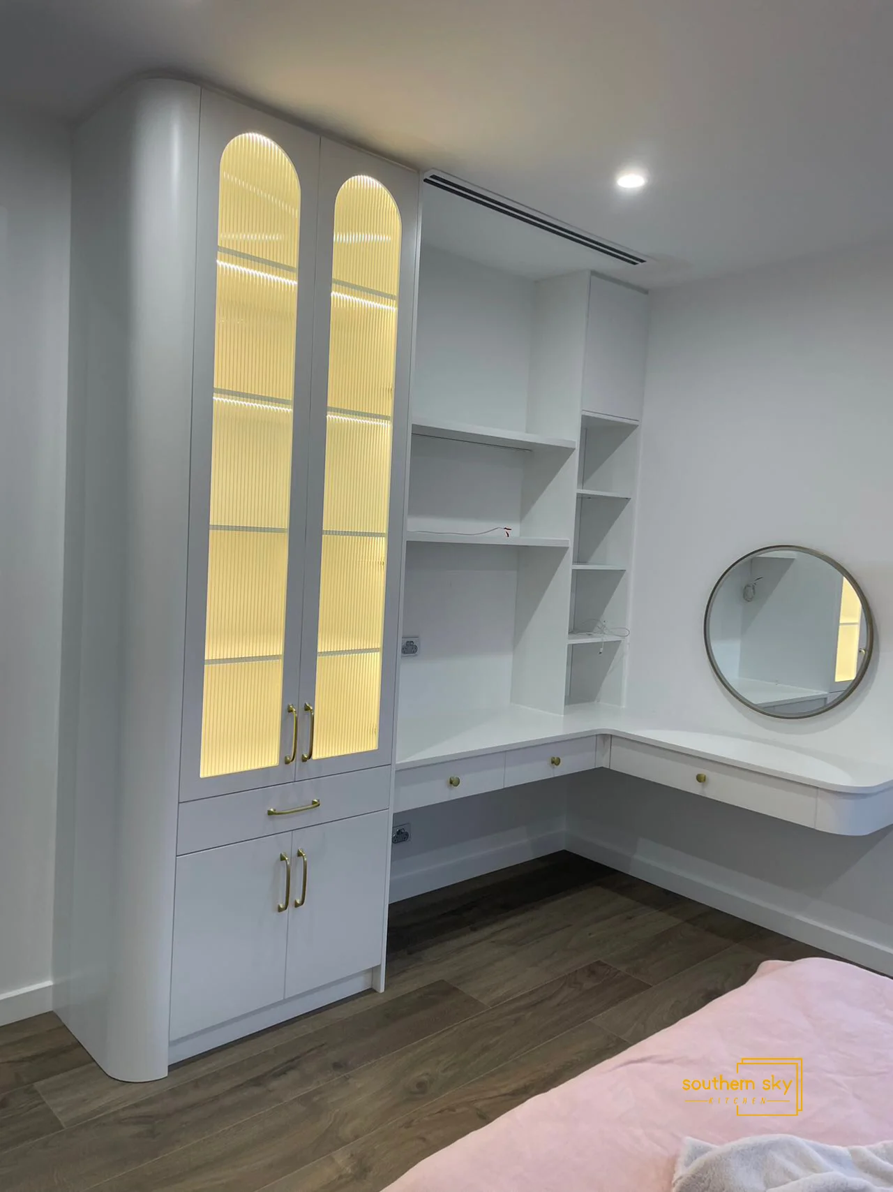 Elegant white cabinet with built-in lighting and sleek gold accents—showcasing superior craftsmanship and modern design elegance.