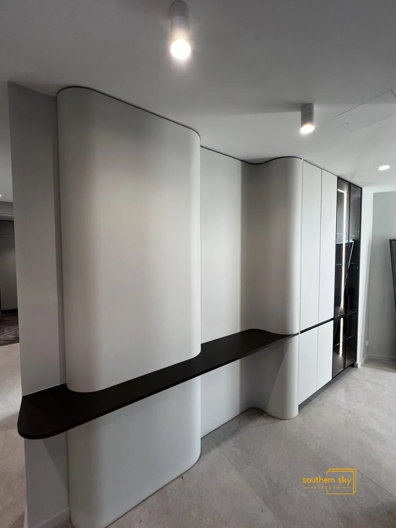 Sleek custom cabinetry with elegant curves, showcasing superior craftsmanship and modern design for a sophisticated space.