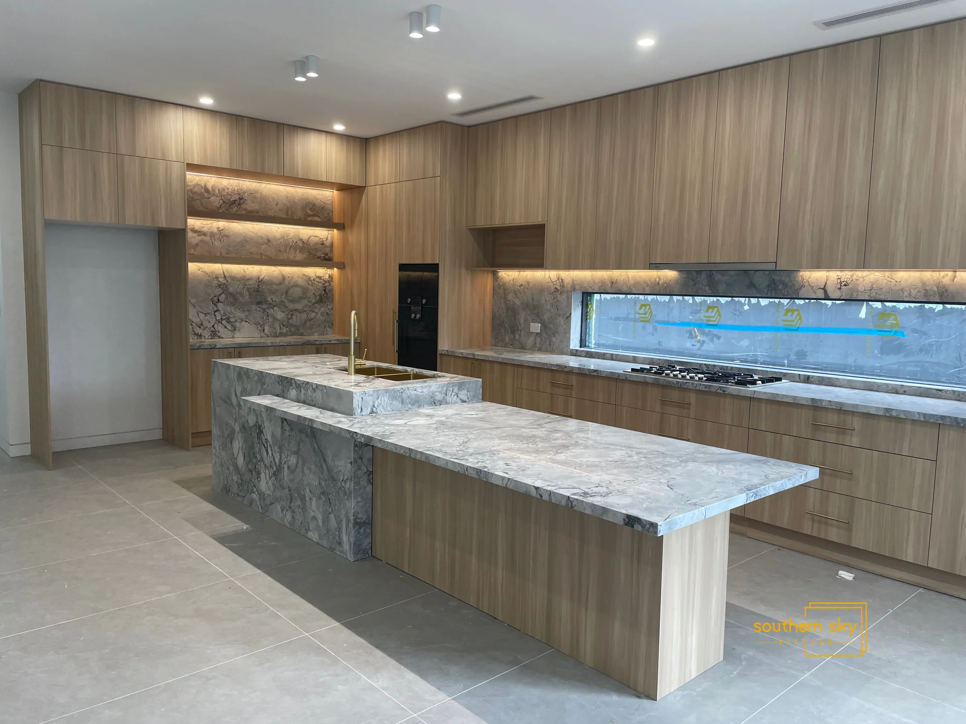Sleek, modern kitchen with luxurious marble countertops and exquisite wood cabinetry for unparalleled design excellence.