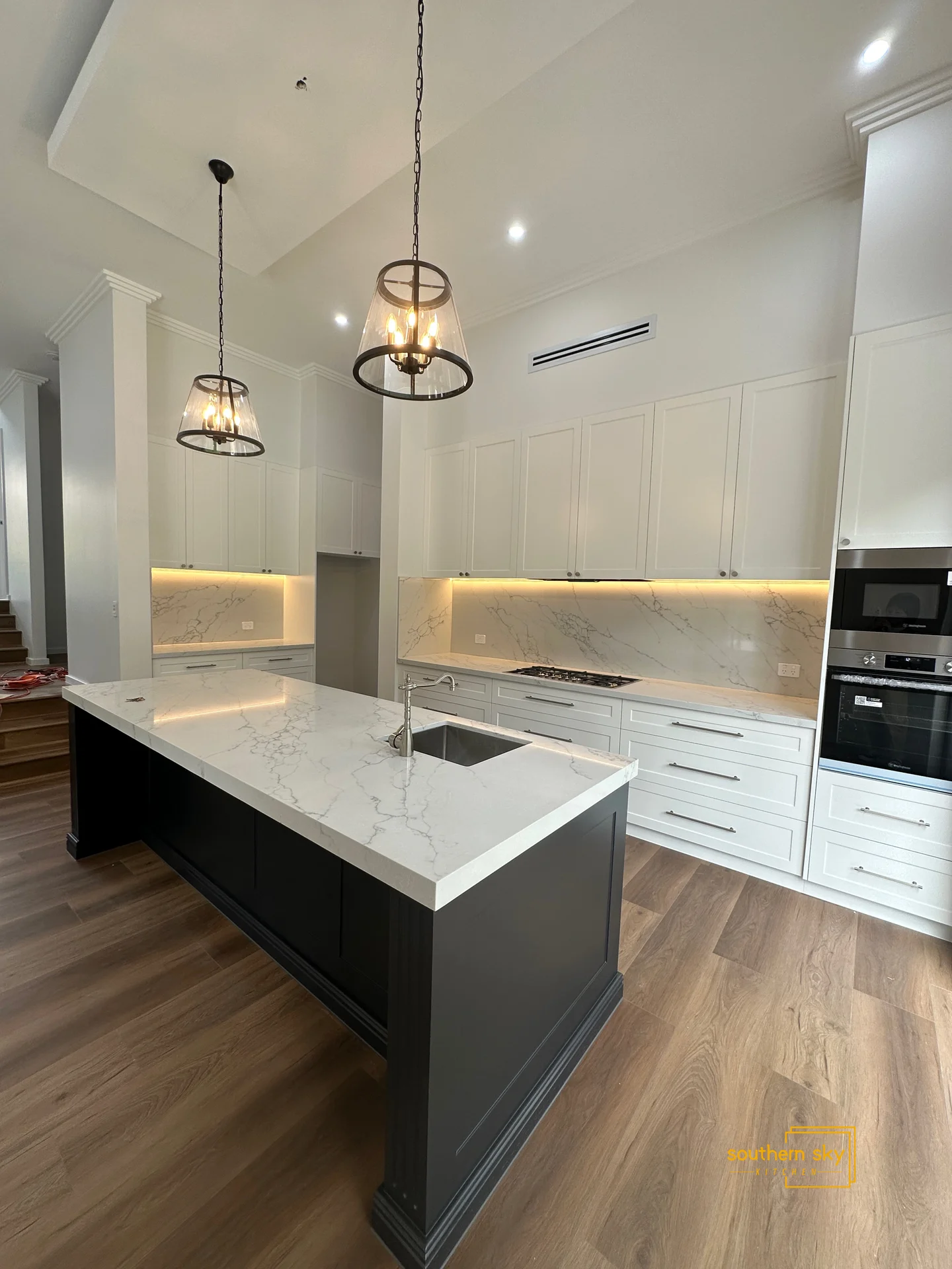 Luxurious kitchen with exquisite marble countertops, sleek cabinetry, and elegant lighting, showcasing superior craftsmanship.