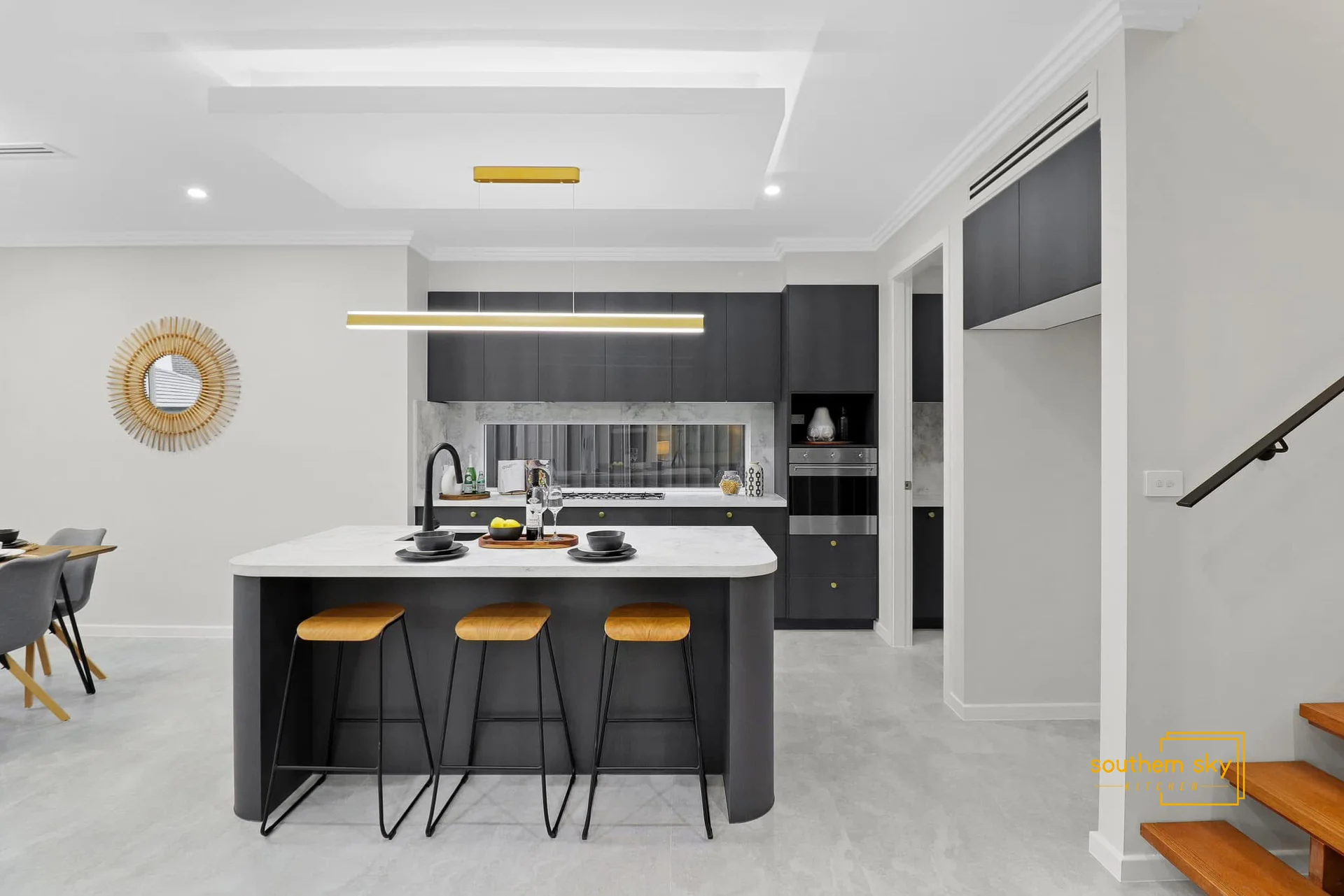 Sleek modern kitchen with elegant island, premium finishes, and exquisite lighting elevates your culinary experience.