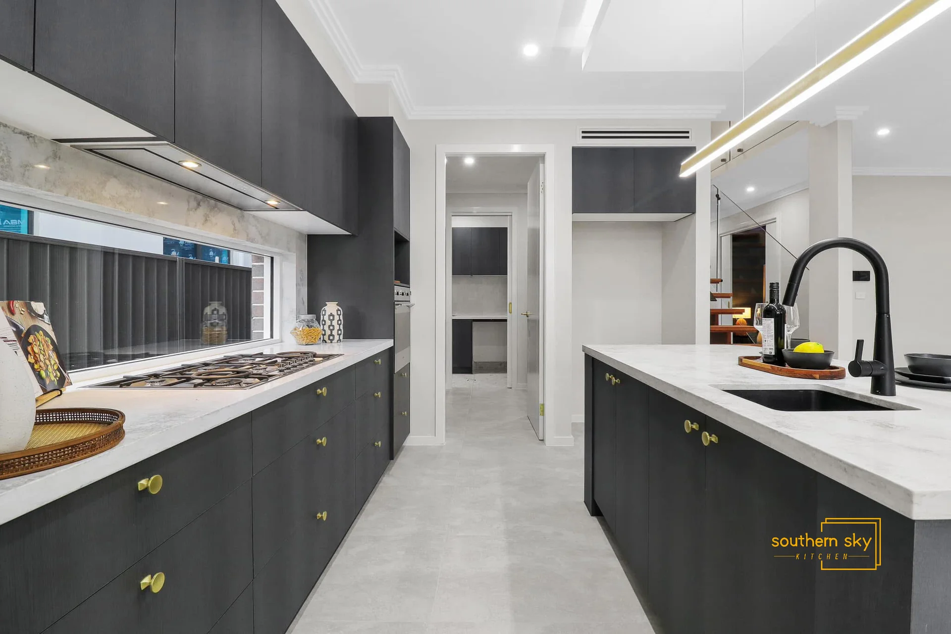 Sleek modern kitchen with high-end black cabinetry, elegant white countertops, and sophisticated design. Impeccable craftsmanship.