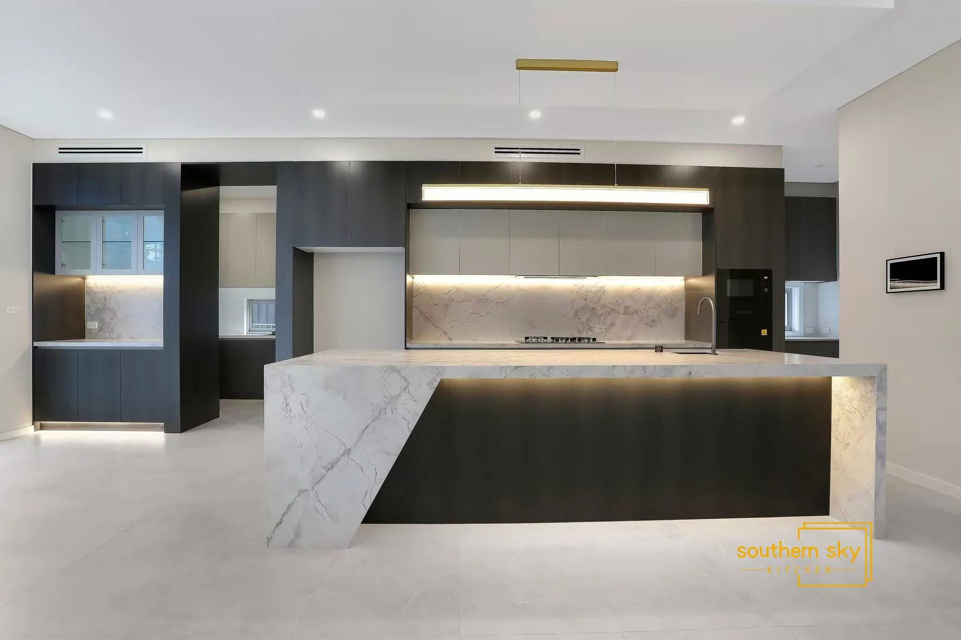 Luxurious kitchen design featuring sleek marble surfaces and elegant lighting, showcasing superior craftsmanship and modern elegance.
