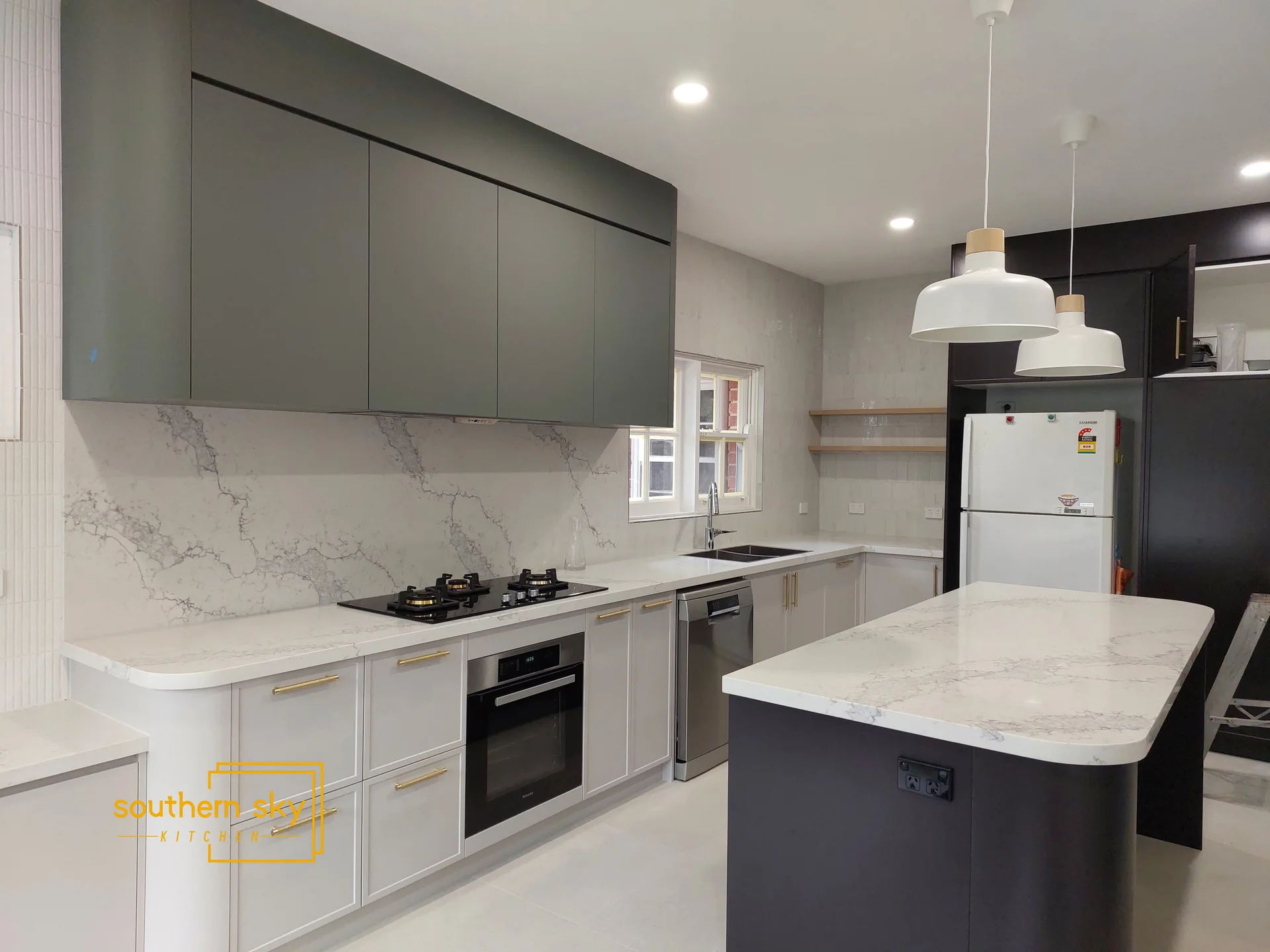 Sleek kitchen design featuring elegant marble countertops, modern cabinetry, and chic lighting, showcasing premium craftsmanship.