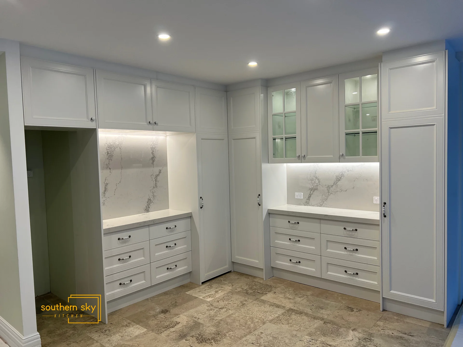 Sleek white cabinetry with marble accents showcases exquisite craftsmanship and elegant design for modern kitchen luxury.