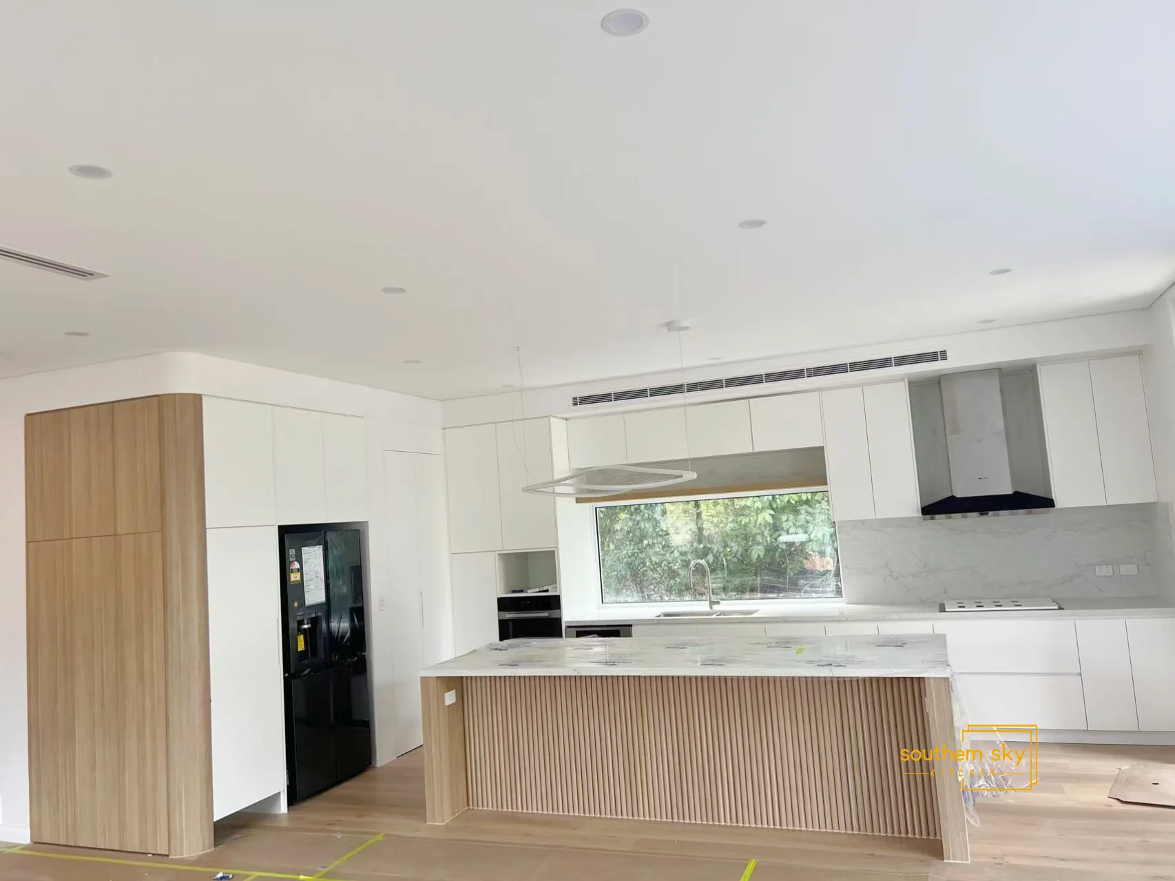 Modern kitchen design with sleek cabinetry, marble countertops, and elegant wood accents, showcasing exceptional craftsmanship.
